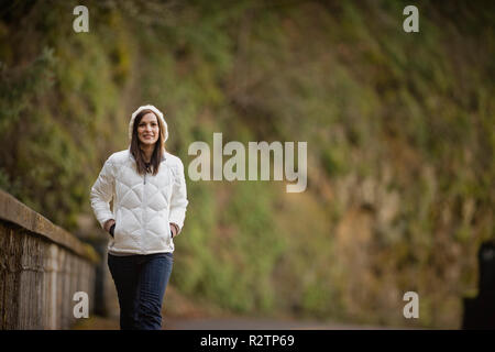 Brunette Donna che cammina vestito in abiti caldi. Foto Stock