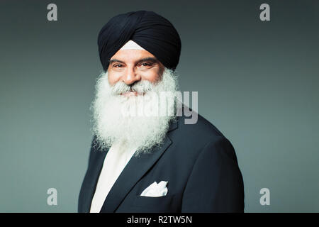 Ritratto sorridente, fiduciosi ben vestito uomo senior indossando turbante Foto Stock