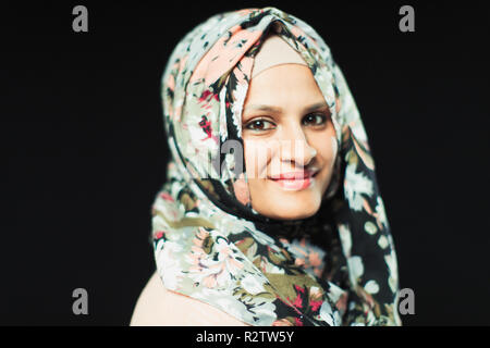 Ritratto sorridente, fiducioso donna che indossa il hijab floreali Foto Stock