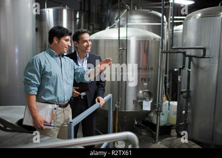 Due colleghi per discutere il lavoro in una fabbrica di birra. Foto Stock