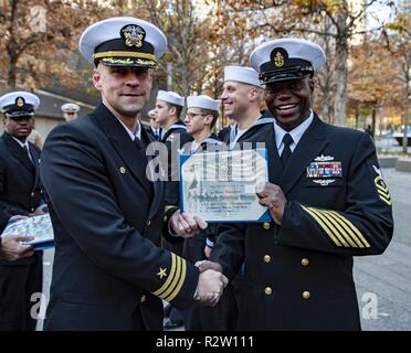 NEW YORK (nov. 10, 2018) Capo Quartermaster Dany Higinio, il dipartimento di navigazione chief petty officer a bordo della harpers Ferry-classe dock anfibio sbarco nave USS Oak Hill (LSD 51), riceve la sua onorevole certificato di scarico da Oak Hill Comandante della Cmdr. Philip Knight prima di ri-l'arruolamento al 9/11 Memorial nella città di New York. Oak Hill è che partecipano nella settimana dei veterani di New York City 2018 per onorare il servizio di tutta la nostra nazione di veterani. Foto Stock