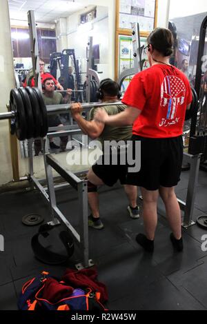 Cpl. Victoria di lepre Coffeyville, Oklahoma guarda attentamente come Staff Sgt. Roberto Manzo di Stewart Florida inizia un altro deadlift ripetizione a Camp Taji. Entrambi i soldati sono da 321il supporto dei vigili del fuoco e tenere premuto il tasto di accensione il sollevamento di record in più eventi presso il camp. Foto Stock
