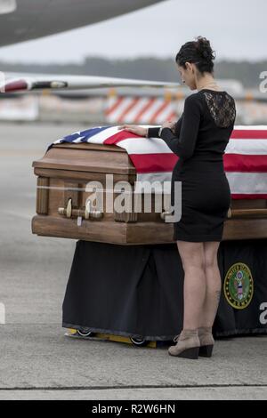 Shawn Slape stabilisce la sua mano sulla bandiera-drappeggiato scrigno di suo marito Sgt. James Slape durante il suo trasferimento onorevole al Marine Corps Air Station Cherry Point, nov. 9, 2018. Slape fu ucciso in azione il 4 ottobre 2018, mentre in servizio in Afghanistan con il 430th Ordnance società a sostegno del funzionamento sostegno risoluto e libertà Sentinel. Foto Stock