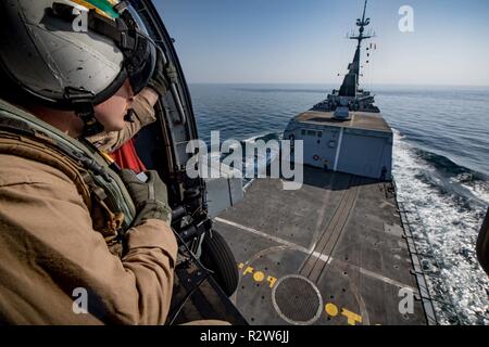 Golfo Arabico (nov. 8, 2018) Aircrewman navale (elicottero) terza classe Cole Cruikshank osserva da un MH-60R Sea Hawk elicottero, assegnato al "vipere" di elicottero Maritime Strike Squadron (HSM) 48 attaccato al guidato-missile destroyer USS Jason Dunham (DDG 109), come si solleva dal ponte di volo della fregata francese FS Courbet (F712) come parte di tre settimane di integrazione di Courbet con la Task Force 55. Jason Dunham è distribuito negli Stati Uniti Quinta Flotta area di operazioni a sostegno di operazioni navali per garantire stabilità marittimo e la sicurezza nella regione centrale di collegamento del Medi Foto Stock