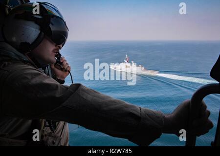 Golfo Arabico (nov. 8, 2018) Aircrewman navale (elicottero) terza classe Cole Cruikshank osserva da un MH-60R Sea Hawk elicottero, assegnato al "vipere" di elicottero Maritime Strike Squadron (HSM) 48 attaccato al guidato-missile destroyer USS Jason Dunham (DDG 109), come si vola dalla fregata francese FS Courbet (F712) come parte di tre settimane di integrazione di Courbet con la Task Force 55. Jason Dunham è distribuito negli Stati Uniti Quinta Flotta area di operazioni a sostegno di operazioni navali per garantire stabilità marittimo e la sicurezza nella regione centrale di collegamento del Mediterraneo e del Pacifico Foto Stock