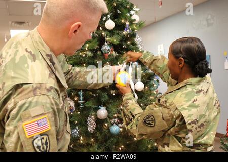 Il comando Sgt. Grande Allen Brooks, sinistro 163L'Intelligence militare battaglione CSM e Col. Deitra L. Trotter, destra, 504th Intelligenza militare Comandante di brigata, mettere i tocchi di rifinitura sul 504th albero di Natale utilizzando la brigata emblema, nov. 15, 2018, Fort Hood, Texas. Workshop Santa è gestito dal 504th MI BDE Disponibilità della famiglia gruppo. Foto Stock