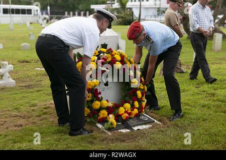 Hagåtña, Guam (nov. 15, 2018) - Bandiera ufficiali che partecipano in un tedesco capstone corso luogo una corona sul SMS Cormoran II headstone durante una ghirlanda recante cerimonia presso l'U.S. Cimitero navale in Hagȧtña nov. 15. Sette marinai a bordo Cormoran II, un navale tedesco nave ormeggiata in Guam's Apra Harbor durante la I Guerra Mondiale, che hanno perso la vita durante un'esplosione e sono stati sepolti nel cimitero. Foto Stock