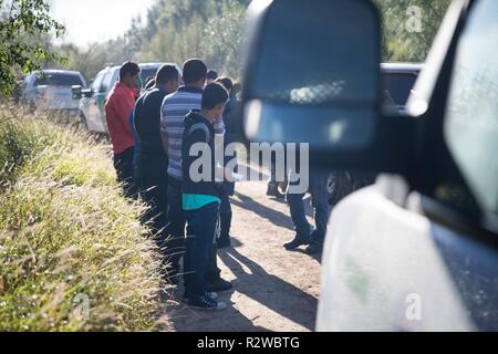 Stati Uniti Pattuglia di Confine agenti arresto illegale gli alieni stanno tentando di entrare negli Stati Uniti dopo aver attraversato il fiume Rio Grande in McAllen, Texas, il 15 novembre 2018. Foto Stock