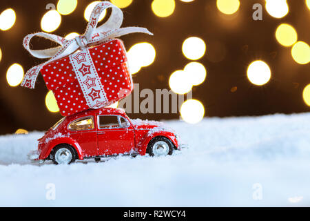 Natale auto rossa con scatola regalo sulla neve Foto Stock