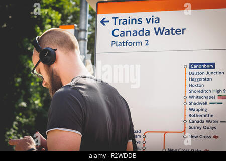 London, Regno Unito - Febbraio, 2019. Un " commuter " su una piattaforma Overground in attesa di un treno. Foto Stock