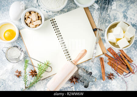 Natale e inverno sfondo di cottura. Utensili da cucina e gli ingredienti per cucinare il lievito - farina, zucchero, uova, burro, latte, bastoncini di cannella, frusta Foto Stock