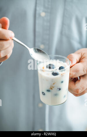 Colazione sana varietà. Yogurt con frutta e semi. Uomo con prima colazione Foto Stock