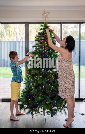 Madre e figlio decorare albero di Natale insieme, Sud Australia Foto Stock