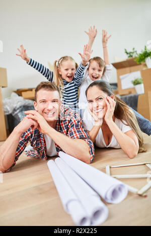 I genitori e i bambini felici celebrare il passaggio ad una nuova casa come home Foto Stock