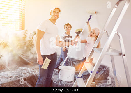I bambini aiutano con la pittura quando rinnovando la propria casa Foto Stock