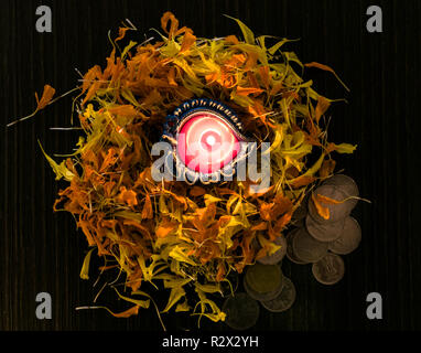 Accesa diya poste sui fiori per celebrare diwali e dhanteras Foto Stock