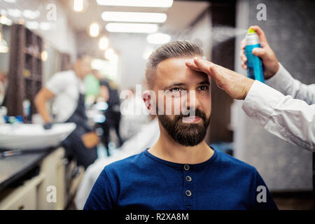 Hipster uomo client haidresser visita e un parrucchiere in un barbiere. Foto Stock