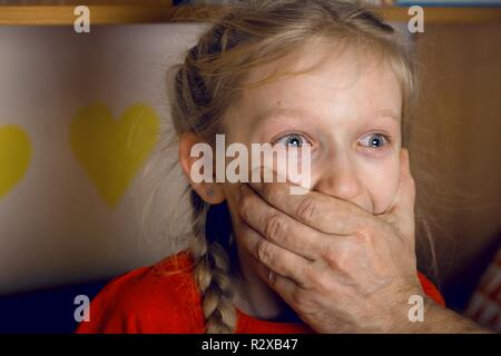 Abuso di minori - l'adulto chiude bambino la bocca con la mano Foto Stock