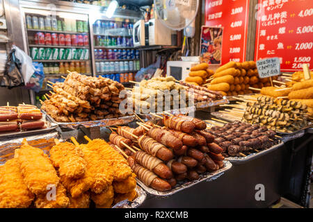 Una bancarella vendendo i diversi tipi di cibo di strada su spiedini di legno in a Myeongdong a Seul, in Corea del Sud. Foto Stock