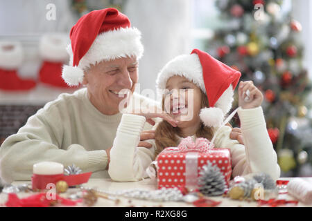 Felice nonno e bambino di cappelli di Babbo Natale la preparazione per il Natale Foto Stock