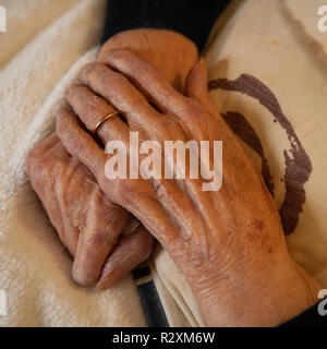 Vecchia Signora con le mani in mano che mostra l'età e l'oro wedding band. Foto Stock