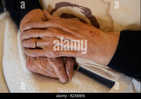 Vecchia Signora con le mani in mano che mostra l'età e l'oro wedding band. Foto Stock