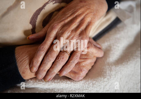 Vecchia Signora con le mani in mano che mostra l'età e l'oro wedding band. Foto Stock