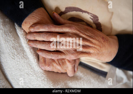 Vecchia Signora con le mani in mano che mostra l'età e l'oro wedding band. Foto Stock