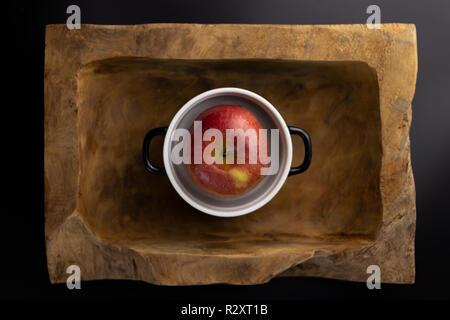 La colazione su un legno vaschetta rettangolare con un bianco e nero pot. Foto Stock