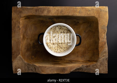 La colazione su un legno vaschetta rettangolare con un bianco e nero pot. Foto Stock