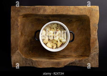 La colazione su un legno vaschetta rettangolare con un bianco e nero pot. Foto Stock