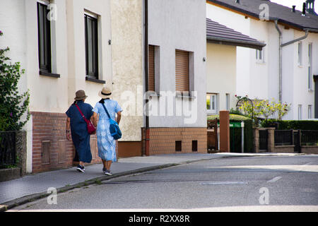 Asian tailandese donne madre e figlia di viaggio e camminare accanto a road andare alla stazione dei bus a Sandhausen village a Heidelberg, Germania Foto Stock