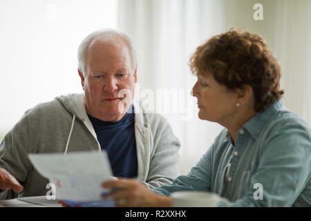 Coppia senior guardando oltre i documenti importanti. Foto Stock