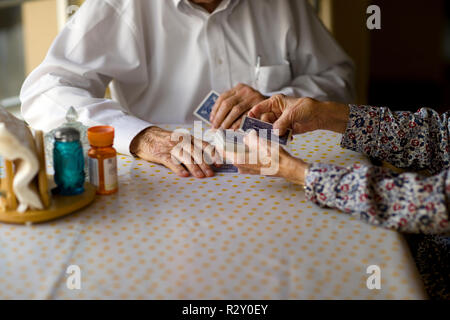 Coppia di anziani godono di carte da gioco insieme al tavolo della cucina. Foto Stock