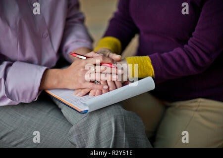 Medico tenendo le mani con il suo paziente. Foto Stock