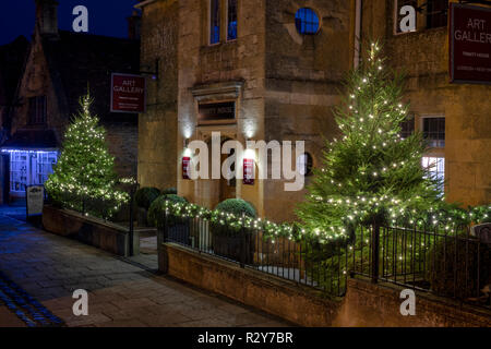 Alberi di Natale con luci di notte fuori casa Trinty art gallery in Broadway, Cotswolds, Worcestershire, Inghilterra Foto Stock