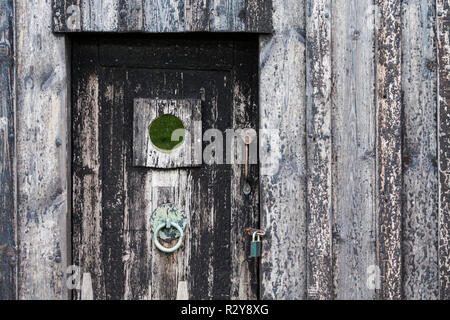 Una porta di legno dal tappeto erboso islandese House, Selfoss, Islanda. La porta e la casa una volta si sarebbe coperto di catrame che è appena visibile. Foto Stock