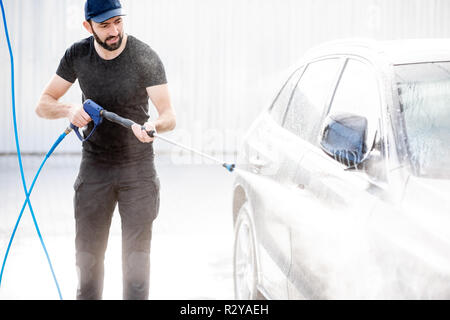 Rondella di professionale di colore nero uniforme di lavaggio auto di lusso con pistola ad acqua su un open air car wash Foto Stock