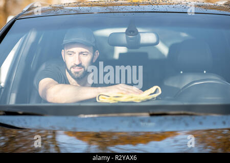 Rondella professionale tergi pannelli auto con giallo microfibra, vista attraverso il parabrezza Foto Stock