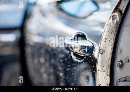 Close-up di una maniglia per porta di un lavaggio auto all'aperto Foto Stock