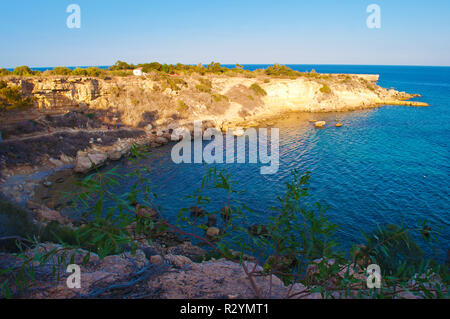 Immagine di una vista sulle scogliere illuminate dal sole e bay nei pressi di Konnos spiaggia nei pressi di Agia Napa, Cipro. Le profonde acque blu intenso e le colline rocciose. Giornata senza nuvole in autunno Foto Stock