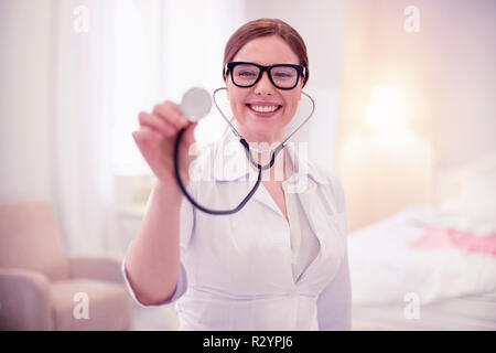 Trasmissione via IR di bell'aspetto medico di famiglia a sorridere mentre si lavora Foto Stock