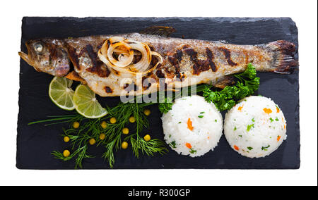 Fritto delizioso pesce trote con riso bianco, verdure fresche e calce su nero che serve board. Isolato su sfondo bianco