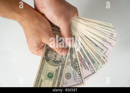 Mano che tiene le fatture del dollaro con sfondo bianco Foto Stock