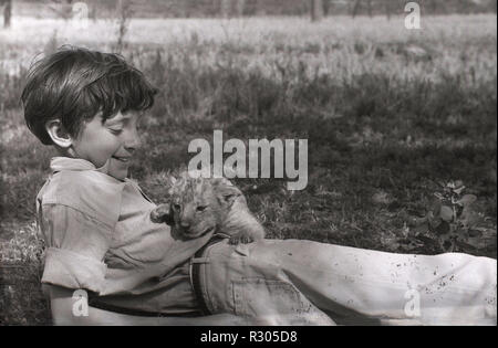 Anni sessanta, giovane ragazzo all aperto con un LION CUB, Camerun, Africa. Foto Stock