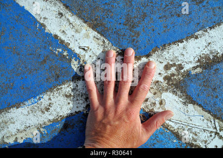 La mano sulla bandiera scozzese, si intraversa - dipinti su roccia Foto Stock