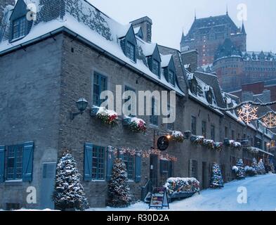 Le strade del quartiere Petit-Champlain durante la stagione di natale dopo una tempesta di neve al tramonto e la vista del Chateau Frontenac Foto Stock