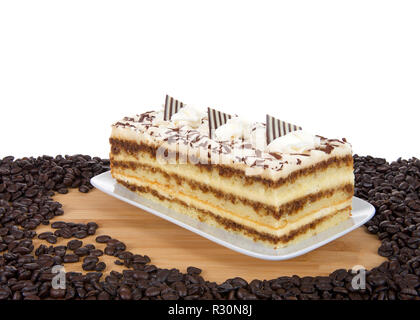 Il tiramisù su una piastra rettangolare sulla tavola di legno isolato su sfondo bianco. Il tiramisù è un popolare dolce italiano con strati di pan di spagna imbevuto Foto Stock