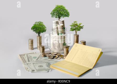 La crescita di denaro per un risparmio di denaro. Albero superiore monete al concetto illustrato ai cambiamenti di un business in espansione Foto Stock