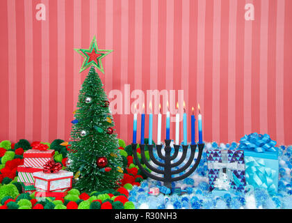 Albero di natale con presenta accanto a Hanukkah menorah candele accese, dreidel, e doni con filato di palline in colori natalizi. Molte più famiglie di fede Foto Stock